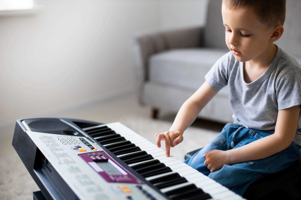 criança pode aprender a tocar teclado piano